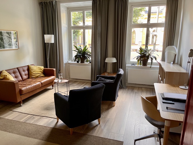 Rikta Psykiatris mottagningsrum i Stockholm med soffa, fåtöljer och stora fönster