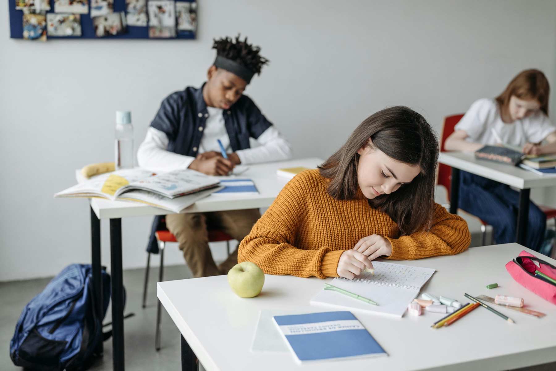 Elever som arbetar vid sina bänkar i ett klassrum, illustration till guide om skolstart med ADHD eller autism